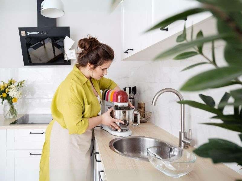 A Woman is Using Food Processor in the Kitchen 