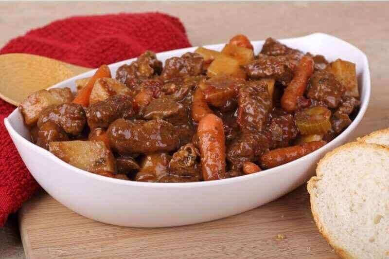 Delicious classic beef stew served in a white large bowl.