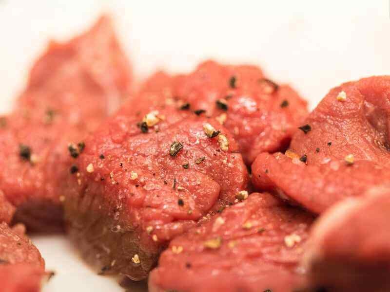 Raw beef cubes seasoned with salt and pepper. 