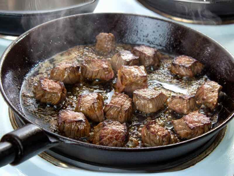 Searing the beef cubes. 