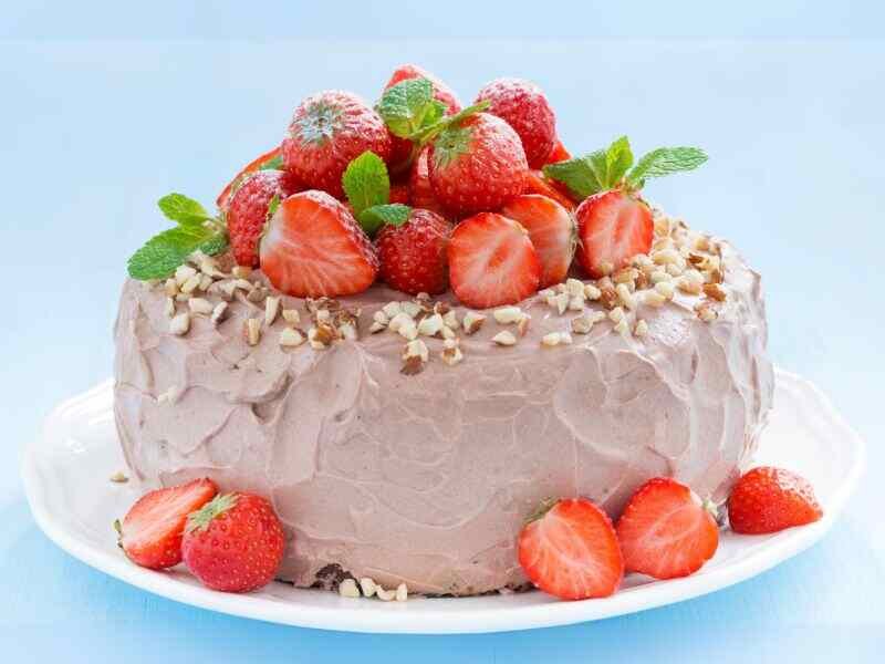 a chocolate pappermint cheesecake on a plate with strawberry toppings