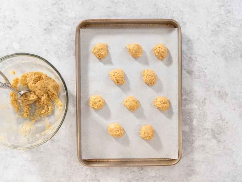 Place the cookie scoop balls evenly on the baking sheet